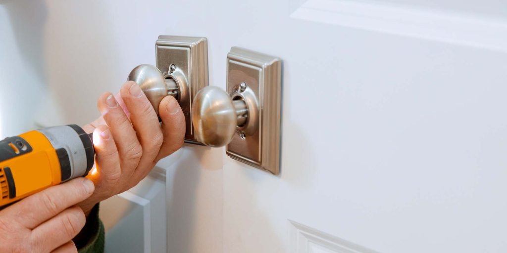 handyman in the door lock in the room door in house